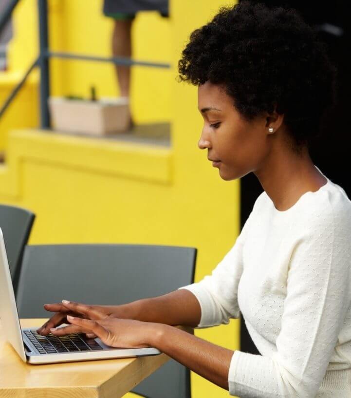 attractive-young-woman-using-laptop-outside-721x817